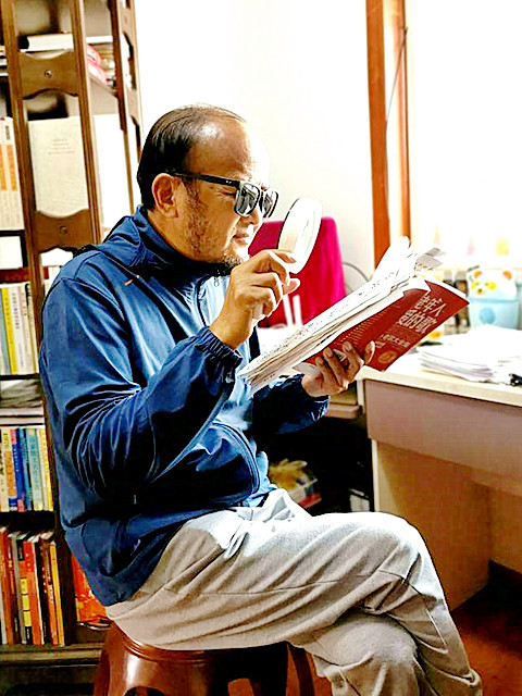8郭汉朝在用放大镜读书学习_副本.jpg